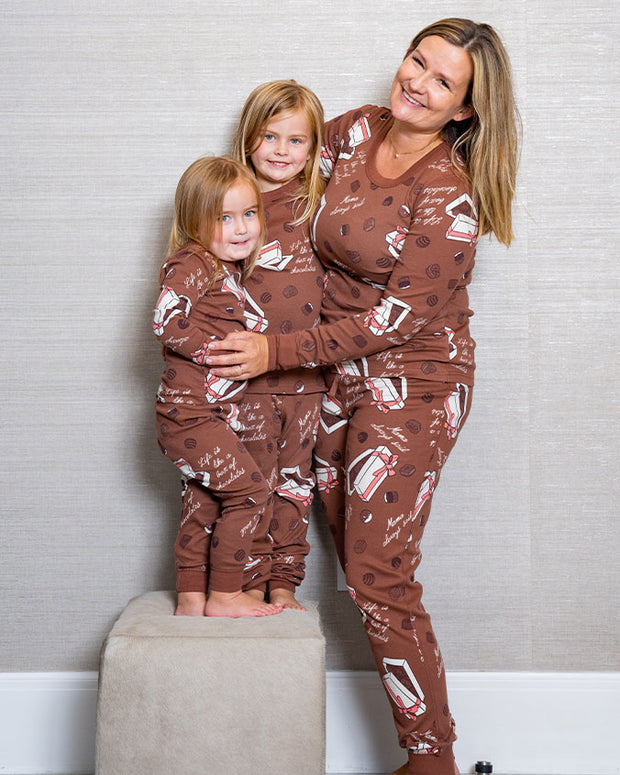 Mother hugging her two daughters from the side while wearing the Box of Chocolates pajama sets.