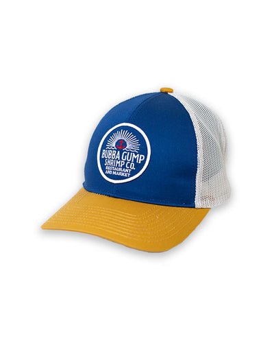 Blue and mustard trucker hat with white mesh on the back. The cap has a front round graphic with a small red anchor and  Bubba Gump Shrimp Co Restaurant and Market wording. 