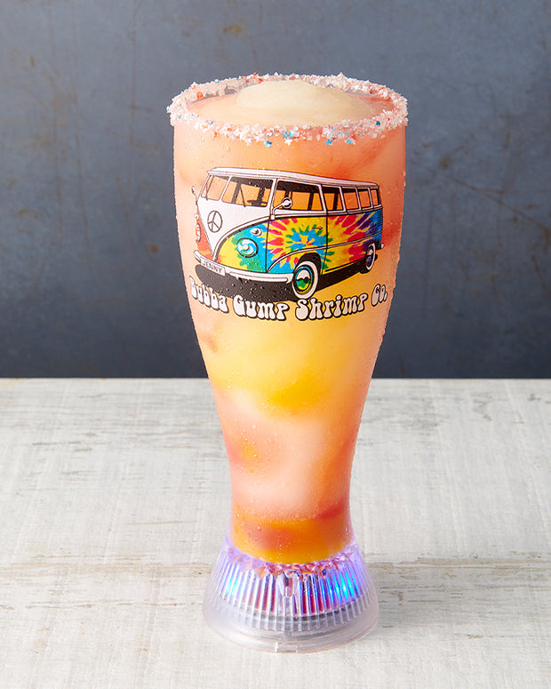 Projector Glass that has a tie-dye Volkswagen Bus with Bubba Gump Shrimp Co. underneath. Featuring an orange drink inside a glass with sugar-coated rim.