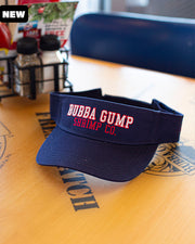 Bubba Gump logo visor placed on top of table at Bubba Gump location with "New" black label in top corner.