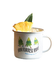 White tin mug with three pine trees running. Under them reads "RUN FORRESRT RUN!" and "Bubba Gump Shrimp Co." on bottom. Cup contains an iced drink, pineapple slice and leave..