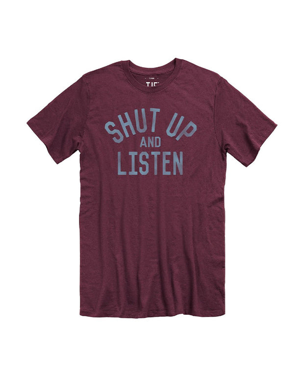 Maroon tee with blue lettering that says "Shut Up And Listen"