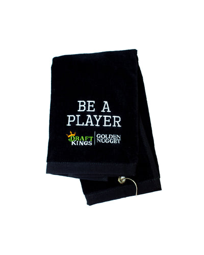 Golf towel with "Be A Player" in white embroidered lettering and Draft Kings/Golden Nugget branding.