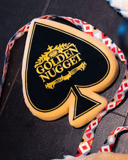 Golden Nugget spade toy on wood flooring with Golden Nugget dog leash in background.