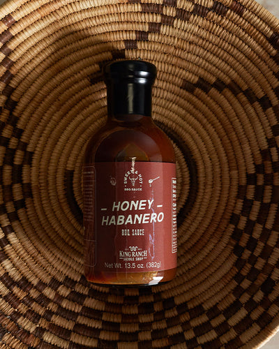 King Ranch Honey Habanero sauce laying in woven basket.