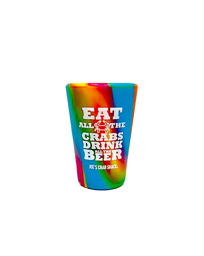 Vibrant tie dye silicone shot glass that says "Eat All The Crabs, Drink All The Beer" in bold white font with Joe's Crab Shack branding.