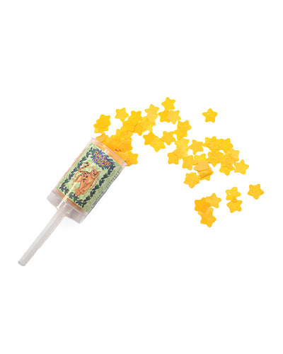 A clear plastic push-pop style container with a colorful label featuring an animated character. It’s filled with star-shaped yellow confetti, some of which are scattered around the container. The label is adorned with greenery and flowers.