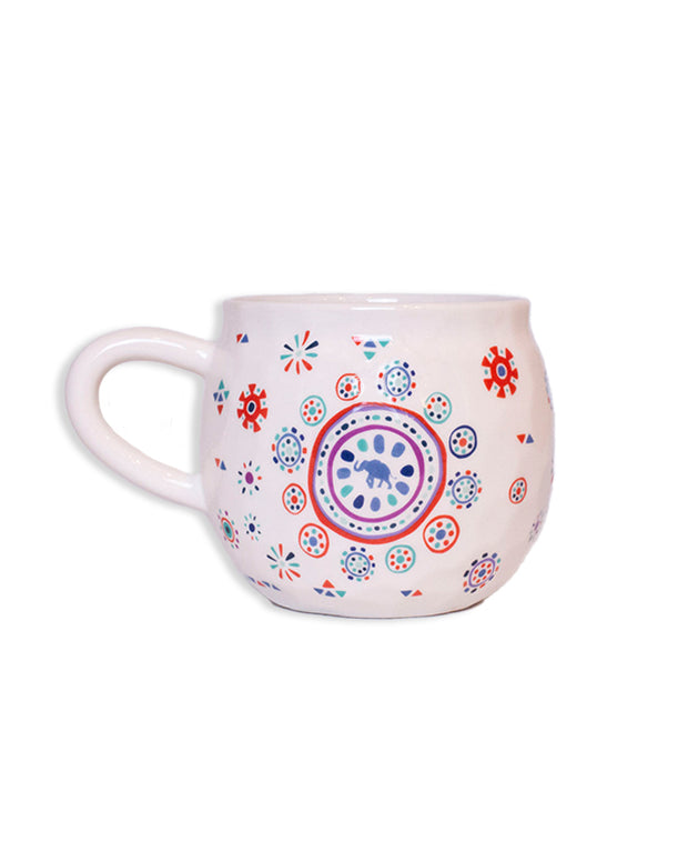 Ceramic white mug with colorful, painted, circular, tribal designs and a small blue elephant in the center.