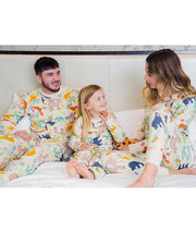 Mother, father, and daughter sitting on the bed while wearing the Jungle Party PJ set.