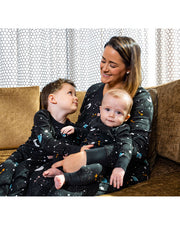 Mother sitting with two young sons on couch while all wear the Galaxy PJ Set.