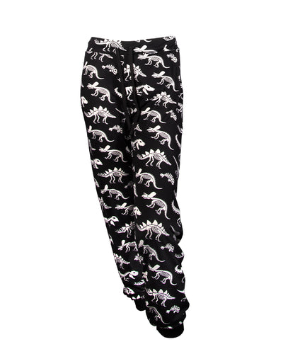Black drawstring pants with dinosaur skeleton pattern in front of white background.