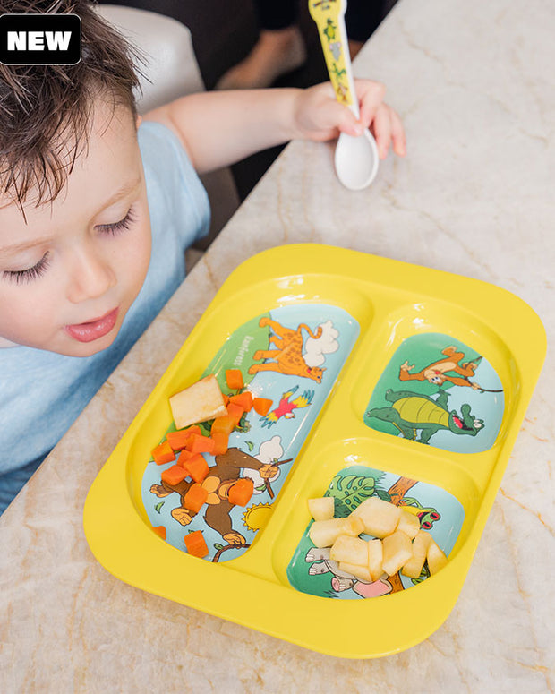 Toddler eating at the table using the Yellow Kids Divided Plate with matching spoon.