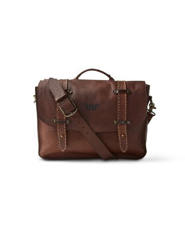 Brown leather saddle bag with buckles, leather shoulder strap, and King Ranch logo in middle of opening flap.