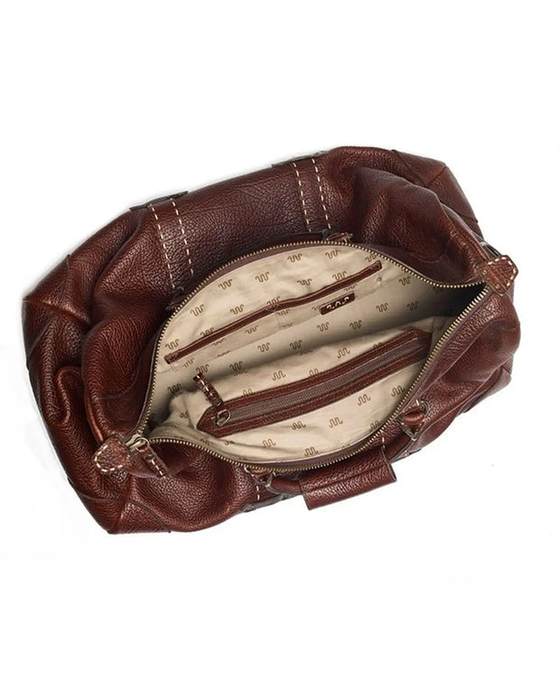 Brown leather weekender bag viewed from the top. The bag is open, revealing inside zipper and compartments lined with fabric with the King Ranch symbol logo. 