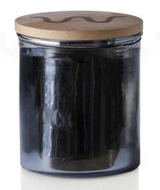Candle with black wrapping and King Ranch logo on lid  in front of white background.