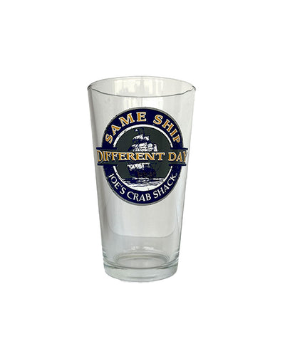 Pint glass with ship design and wording saying "Same Ship, Different Day" in yellow with "Joe's Crab Shack" in white underneath.