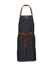 Denim apron with brown straps and King Ranch branding on neckline in front of white background.