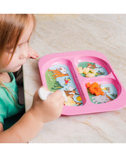 Toddler eating at the table using the Pink Kids Divided Plate and matching print yellow spoon.
