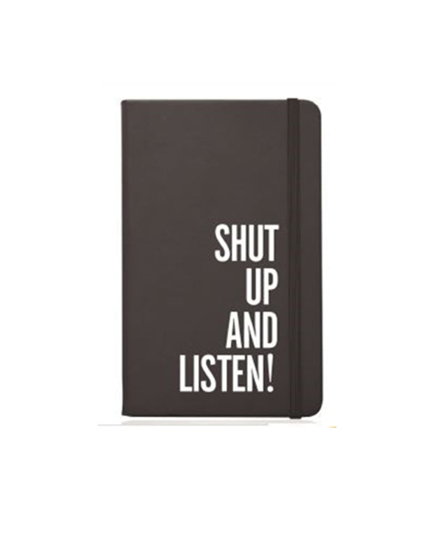 Notebook with dark brown leather cover that says "Shut Up And Listen!" with brown strap to close notebook.