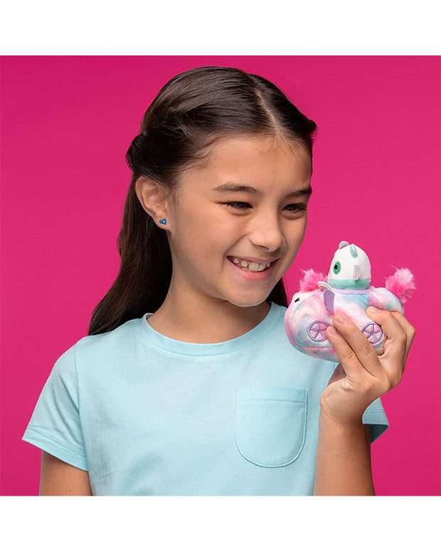Girl wearing plain teal tee holding Felix the Cat and Pink Pig car plushies with a smiling face in front of hot pink background.